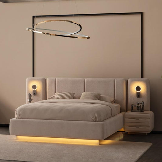 A modern bedroom featuring a low-profile upholstered bed with a warm yellow under-bed light, matching beige nightstands and a rug, a vanity with a round mirror, and a minimalist ring pendant light.